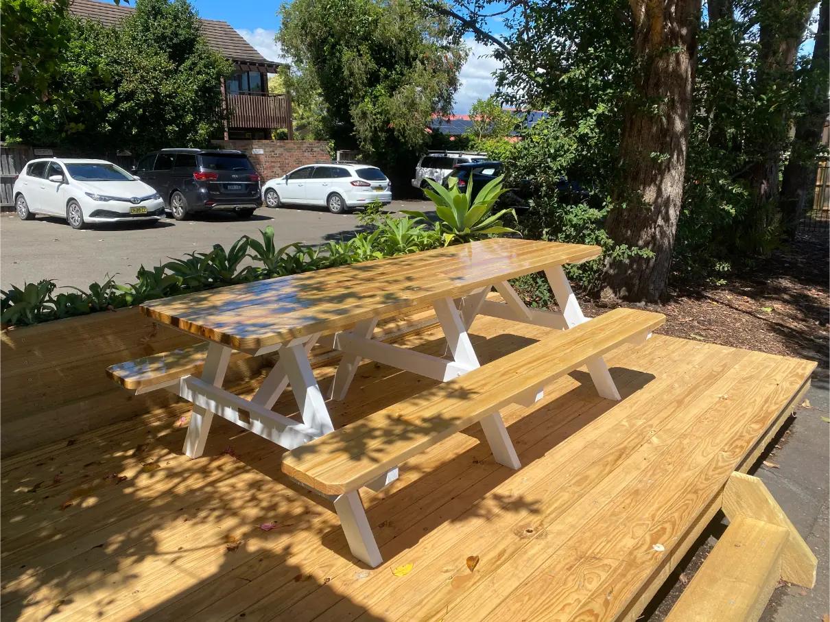 White leg picnic table with custom stain top suited for events, venues, and outdoor gathering areas in Australia