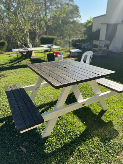 Dark timber top picnic table with white legs by Auscraft, suitable for stylish outdoor use in Australian gardens and patio areas