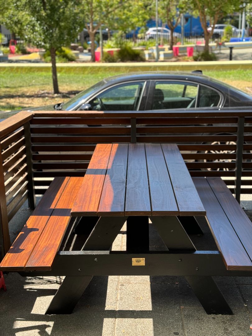 Walnut top heavy duty picnic table with black legs, ideal for restaurant outdoor dining areas needing durable and stylish seating in Australia