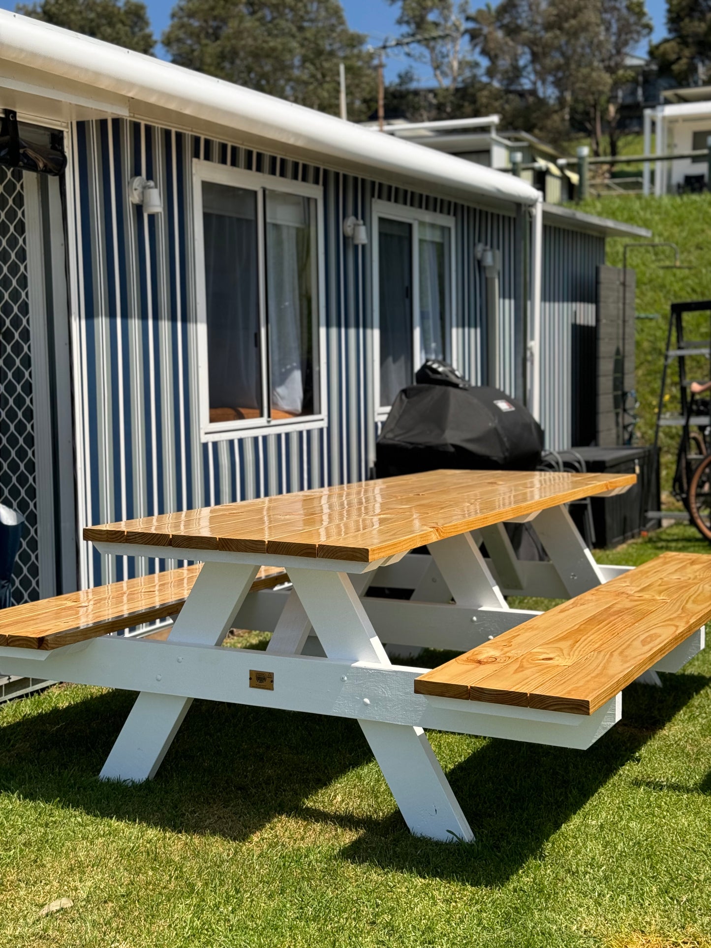 Premium heavy duty picnic table with white legs and a varnished timber top, built for high-traffic outdoor areas requiring durability, weather protection, and a refined finish in Australia