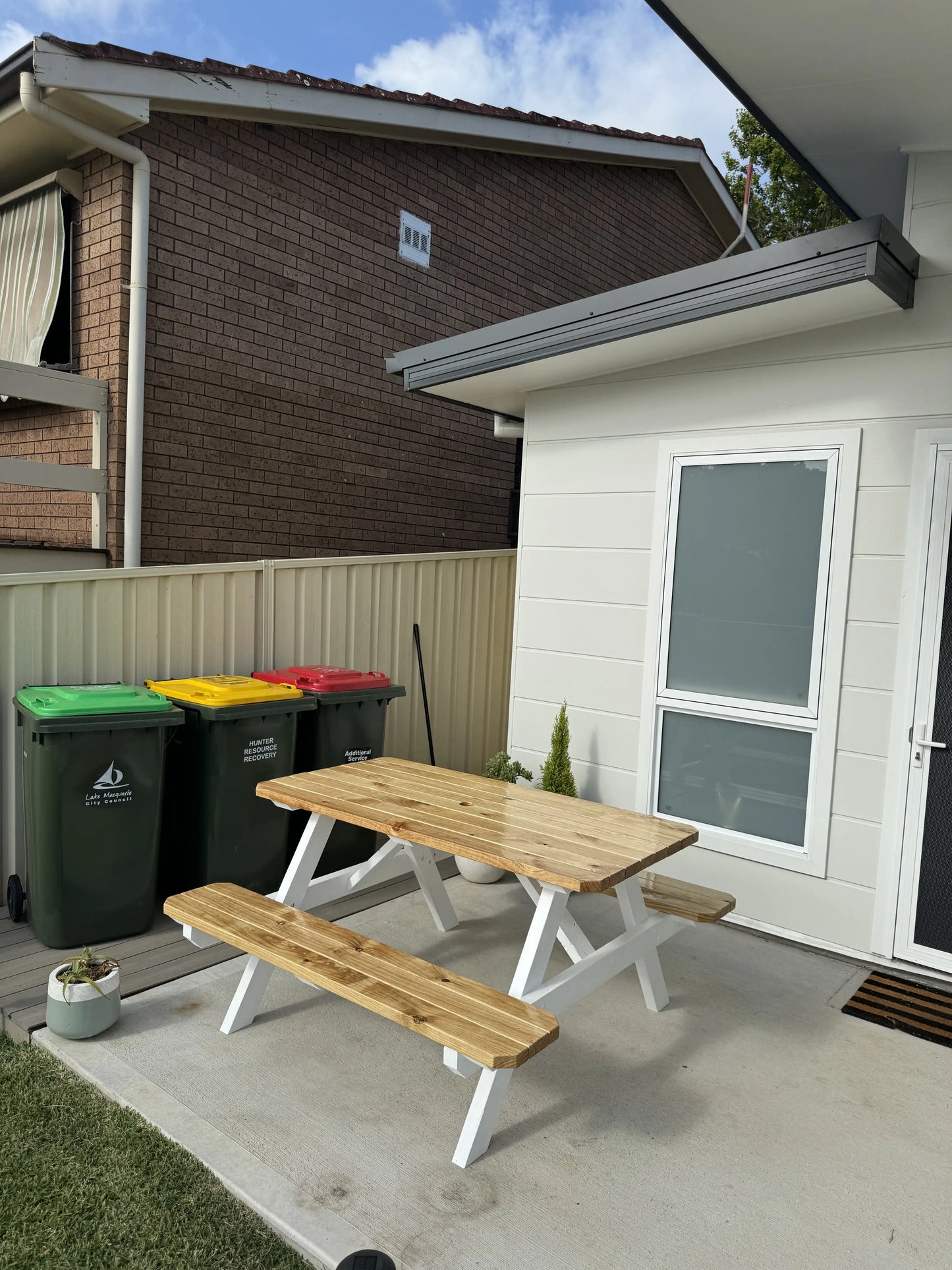 varnished pine picnic table with white legs outdoor garden Australia