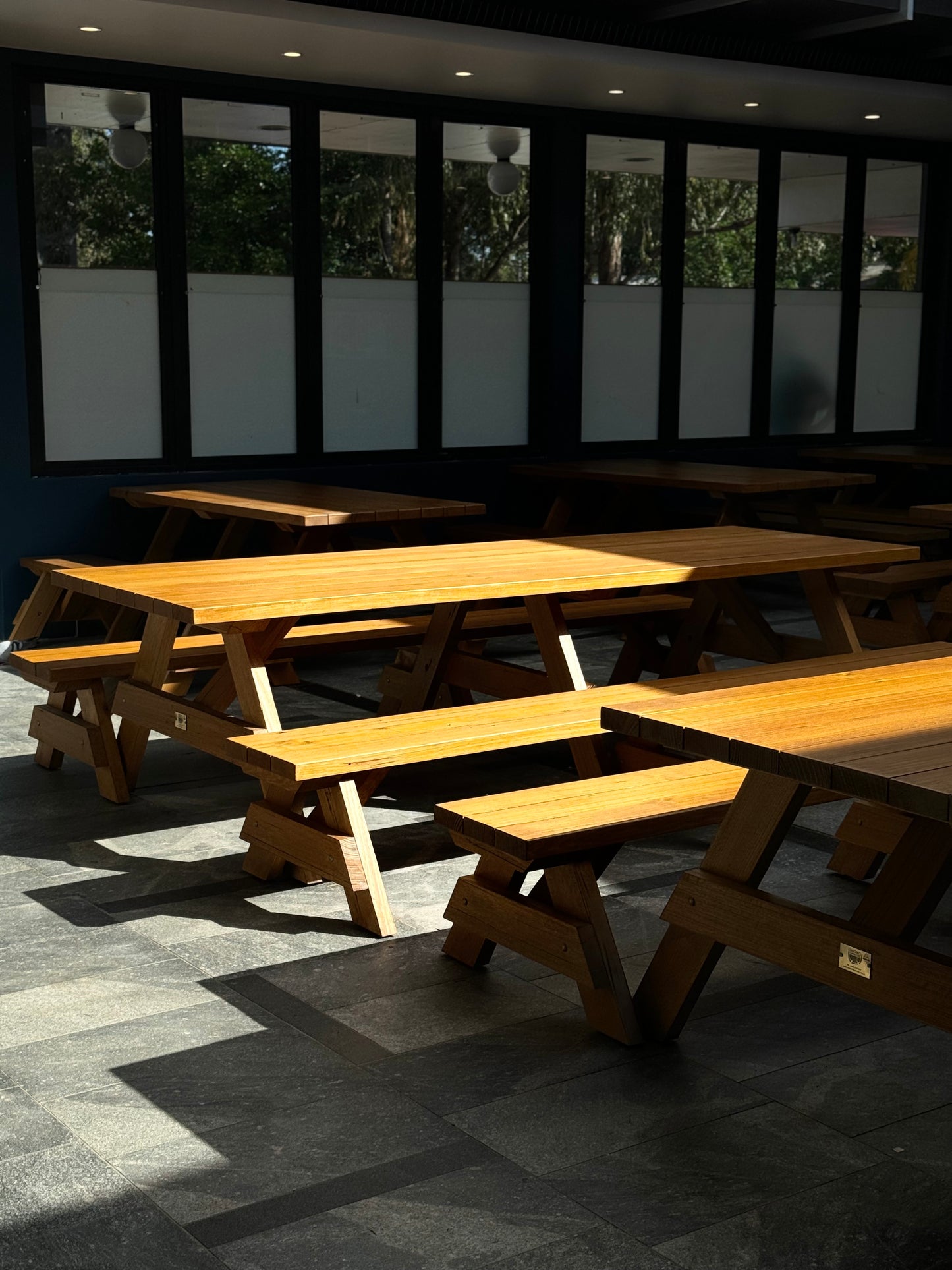 Varnished walnut hardwood picnic table suitable for public parks and open outdoor areas in Australia